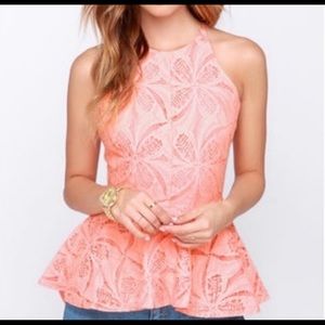 Light orange/ Peach halter top with a crisscross low back. In a lace detail.